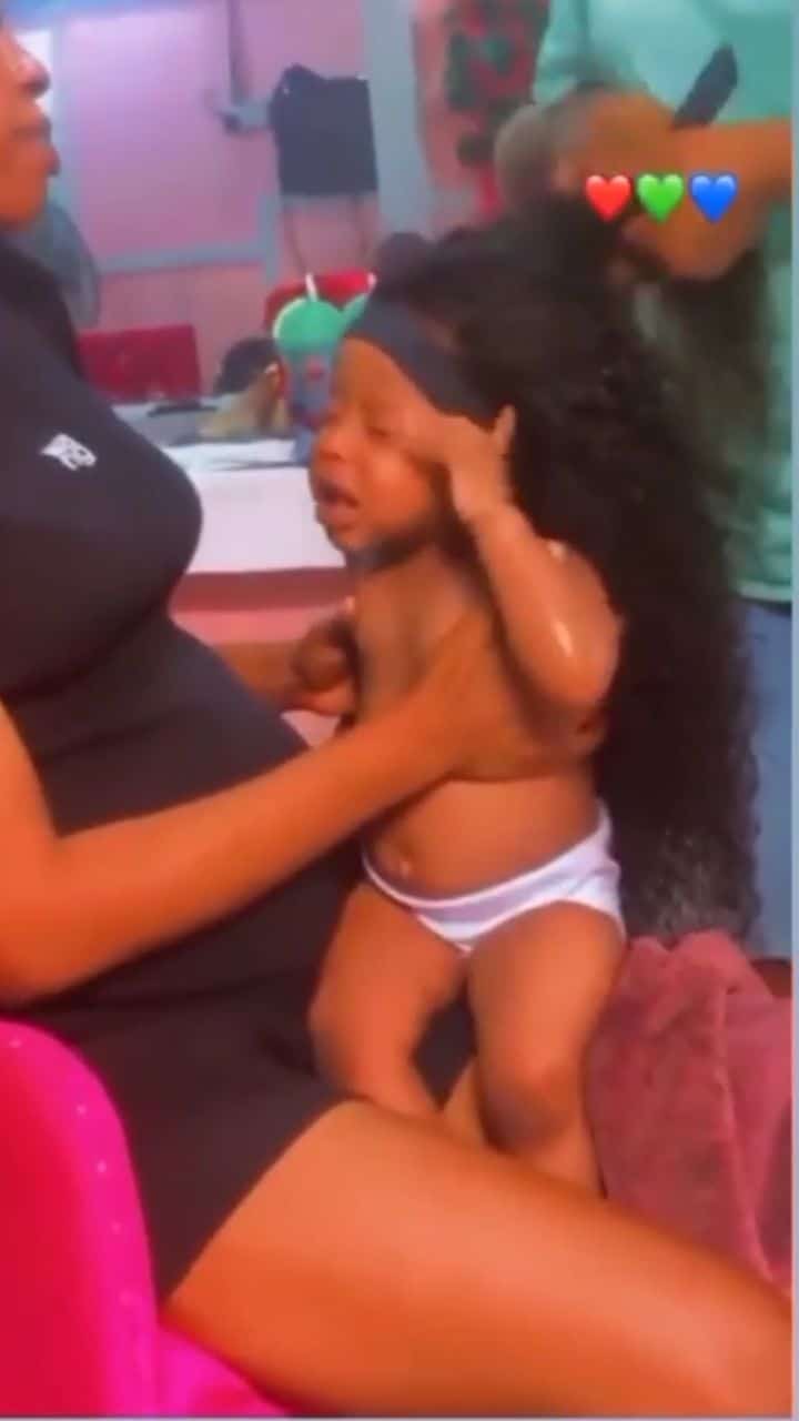 "So many untrained children making children" - Reactions as lady installs wig on baby's head (Video)