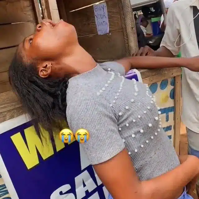 Onlookers gather to support lady acting strange after alighting bike (Video)