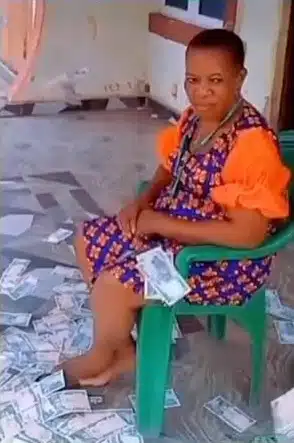 Mother acts unbothered as son sprays her loads of cash (Video)