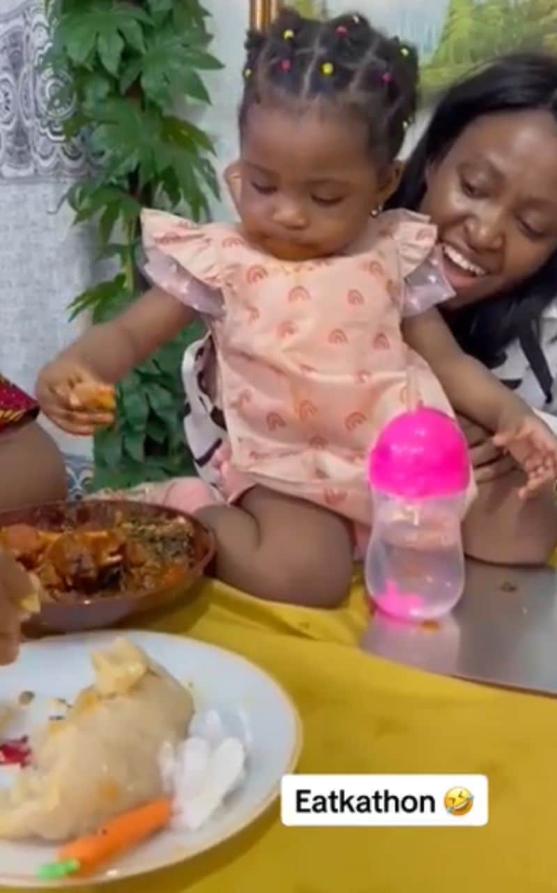 Baby causes a stir as she drags bowl of eba with mother (Video)