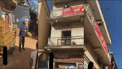 Man loads packs of goods to two-story building by flinging in the air