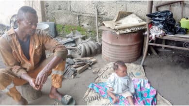 Nigerian mechanic spotted with 7-month-old baby at work after wife reportedly abandons them