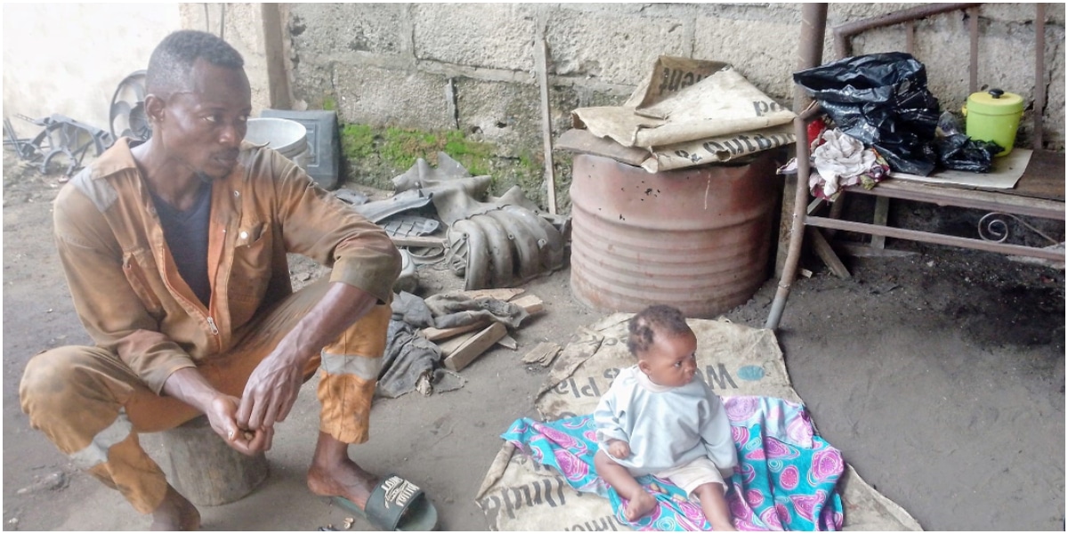 Nigerian mechanic spotted with 7-month-old baby at work after wife reportedly abandons them