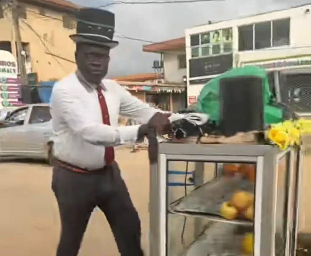 Nigerian man raises eyebrows as he sells fruits in full corporate wear