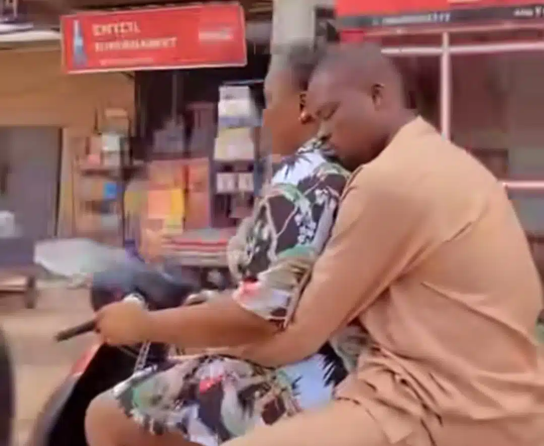 Nigerian man sweetly embraces wife while she drives motorcycle, captures hearts online 
