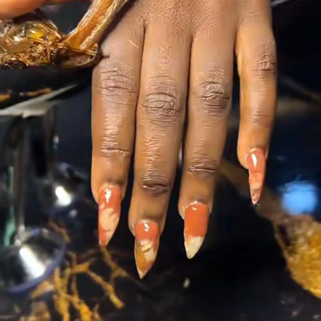 Nigerian lady takes fashion to the next level by applying fish to her nails