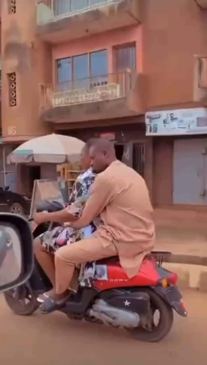 Man seen relaxing peacefully on his woman as she rides okada